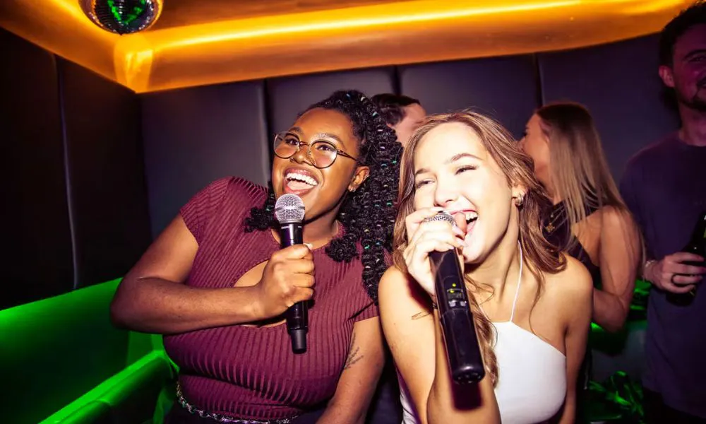 a group of girls singing karaoke