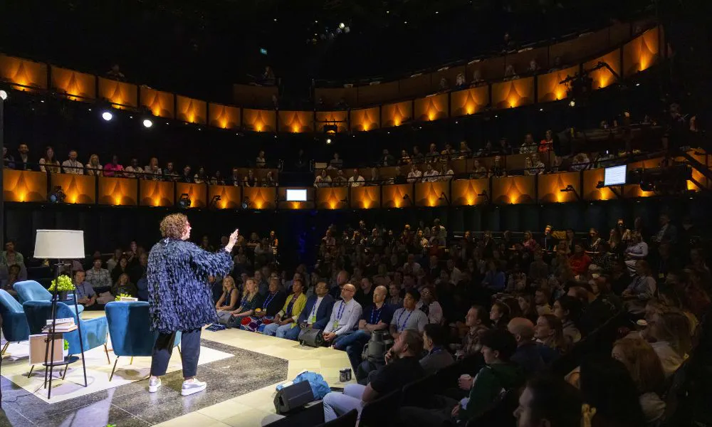 a woman performing at a theatre in front of a crowd