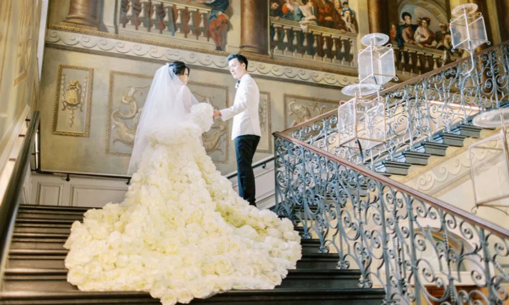 a bride and groom posing on a grand staircase