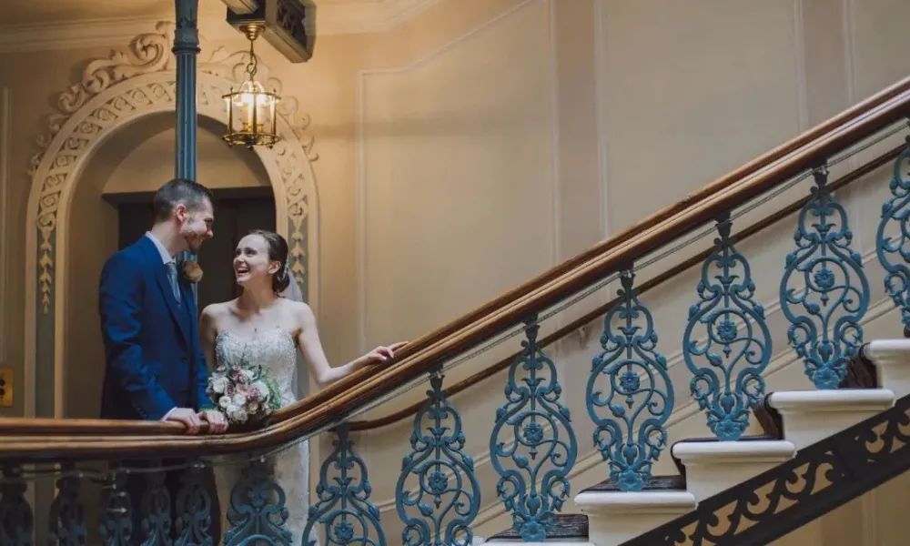 Bride and groom standing on a staircase 