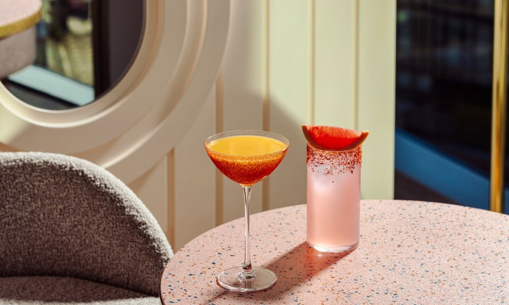Two summery cocktails on a pink marble table