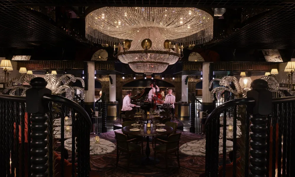 musicians in white sutis play in an ornage bar