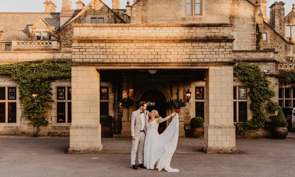 Bride and groom infront of manor house wedding venue