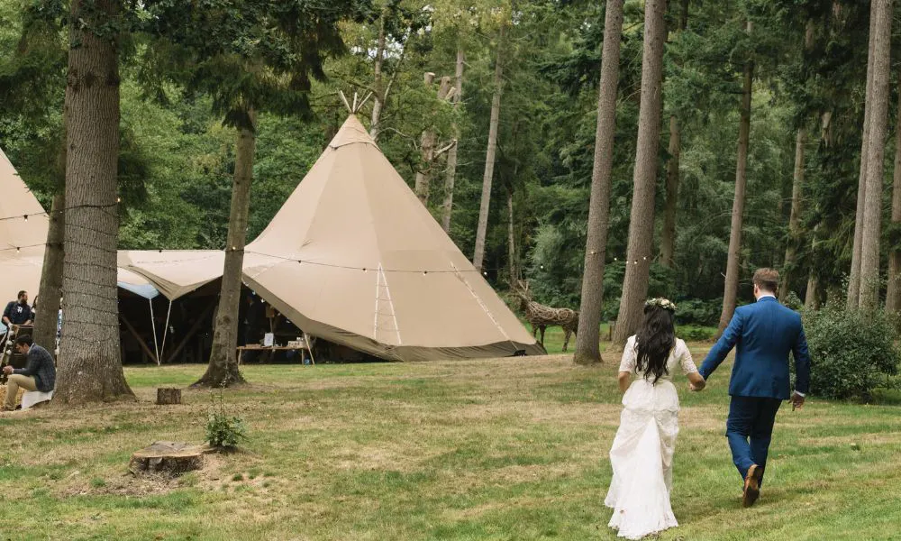 Couple walking to tipi at the woodland at wasing