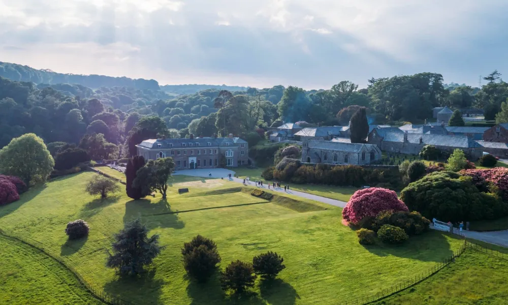 Large manor house with lawns and wedding guests