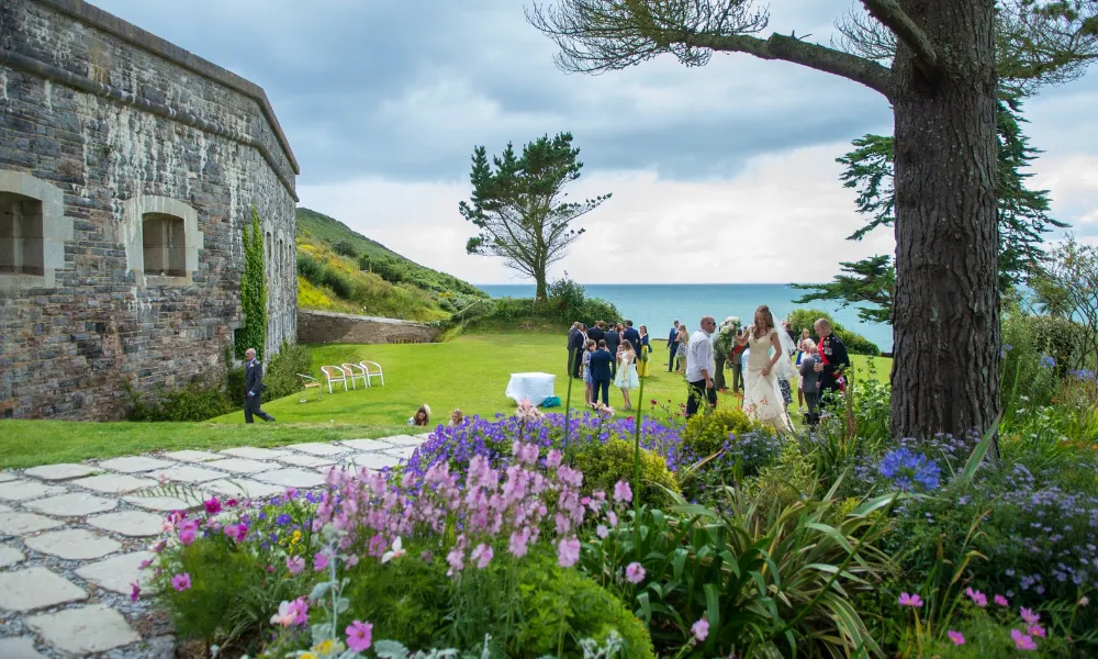 Old cornish fort by the ocean with wedding guests