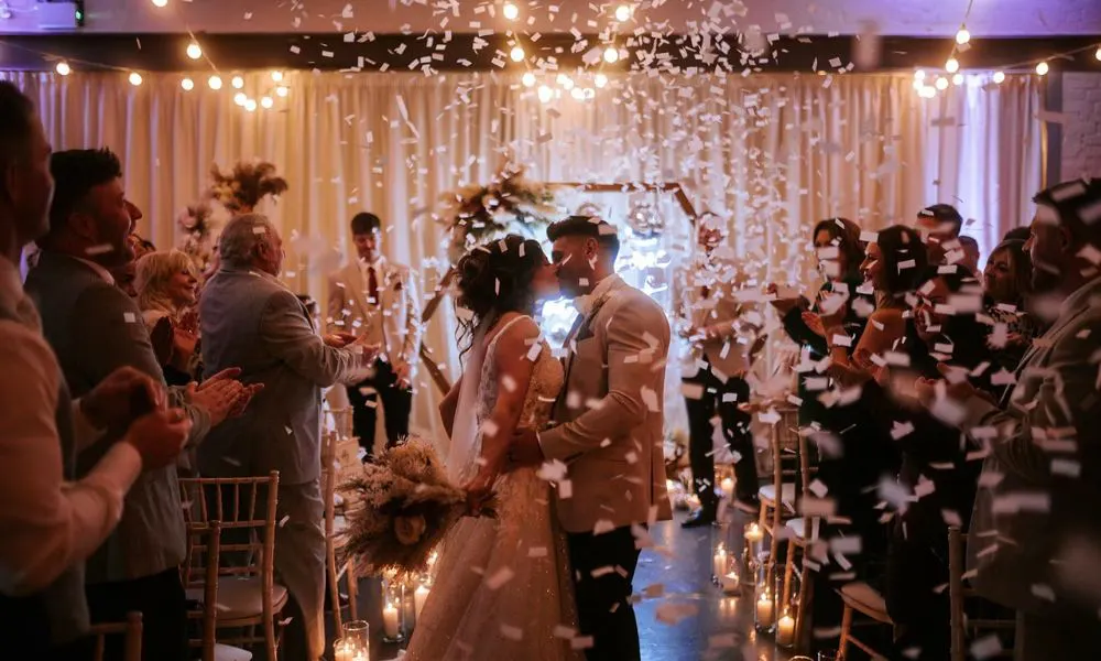 a bride and groom kissing at a wedding ceremony