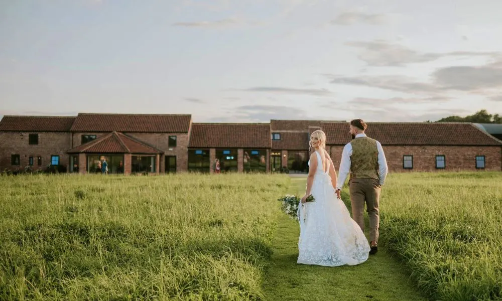 a bride and groom posing in from of Thirsk Lodge Barns