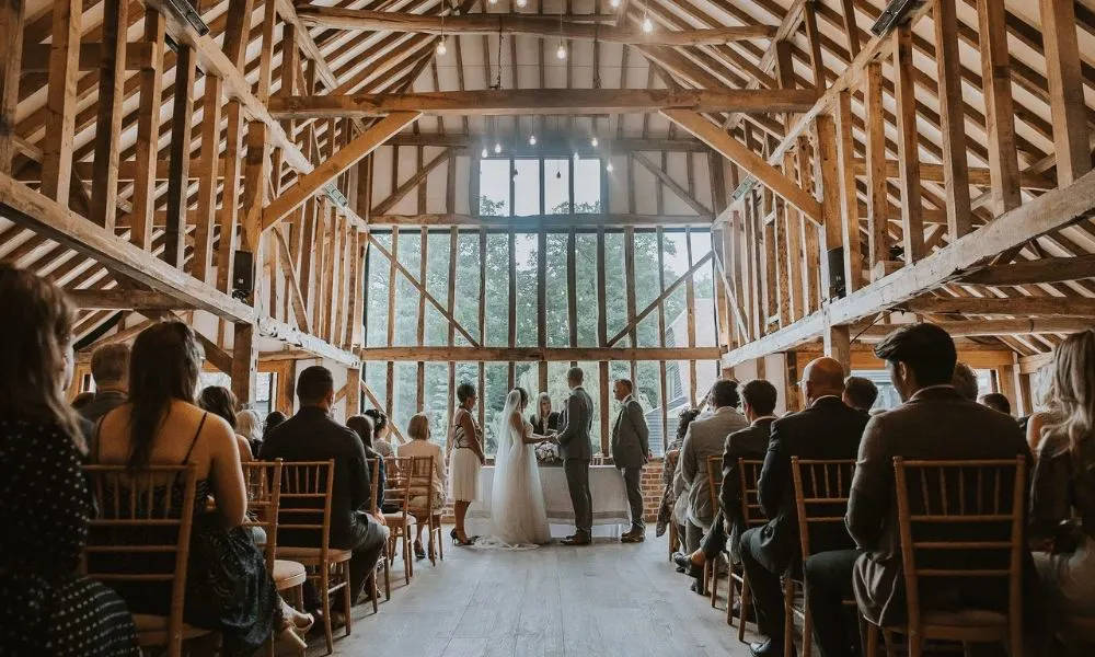 a bride and groom getting married in an idyllic barn wedding venue