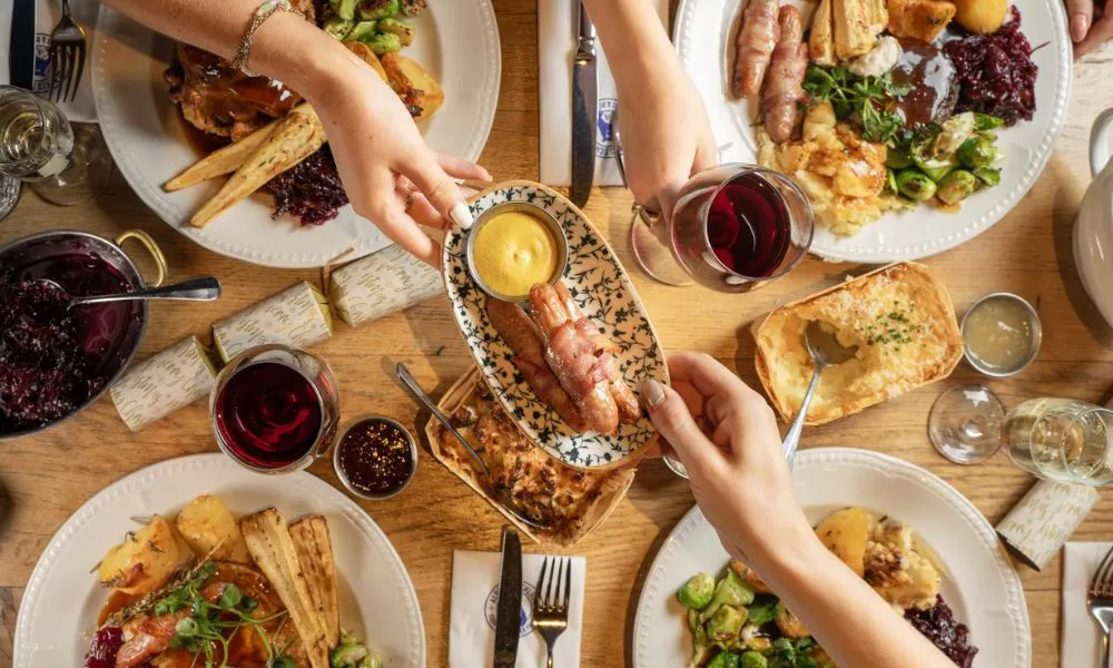 group dining with plates of festive roast dinners