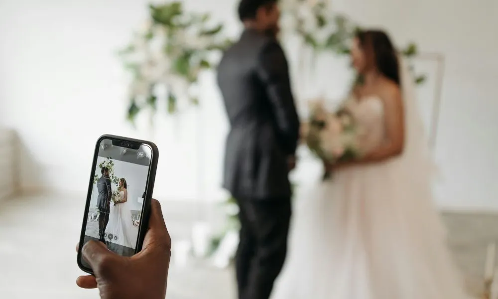 Hand taking photo of couple on iphone