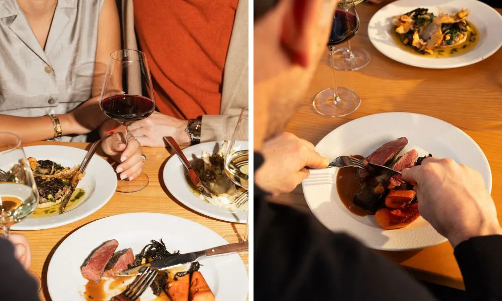 guests sharing red wine and steak with carrots and jus