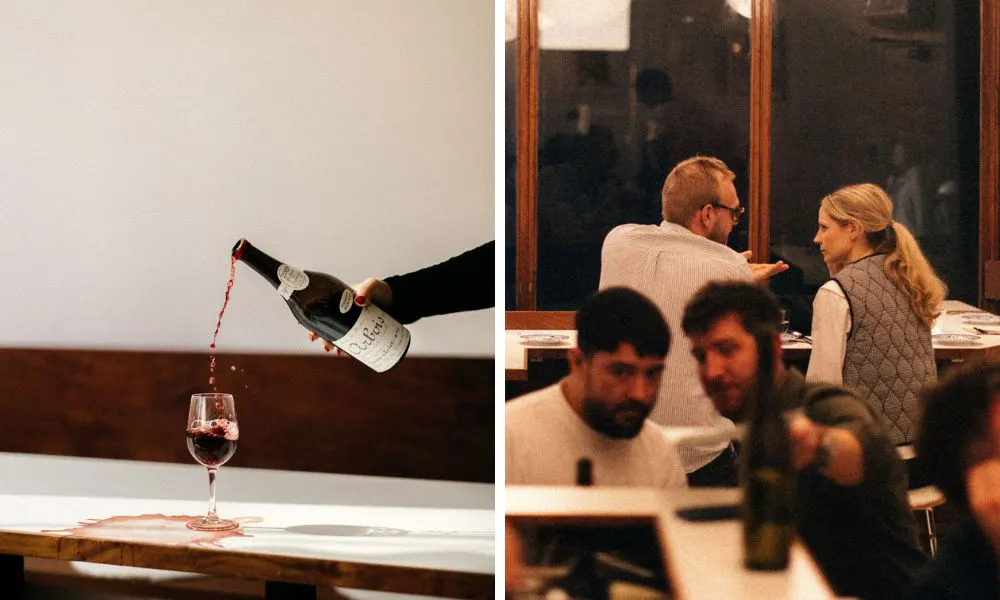waiter pouring a glass of red wine and diners chatting