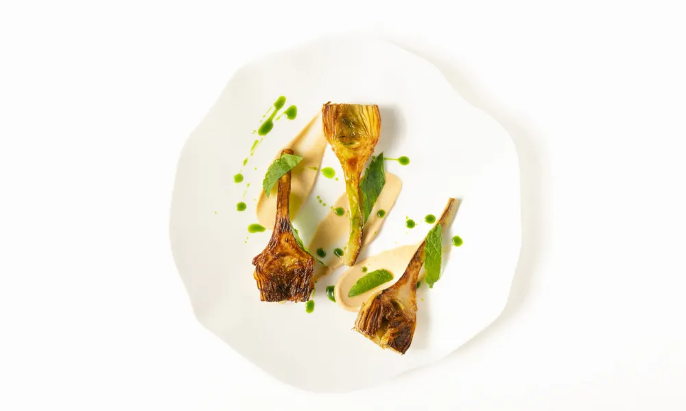 Fine dining dish on a white textured plate