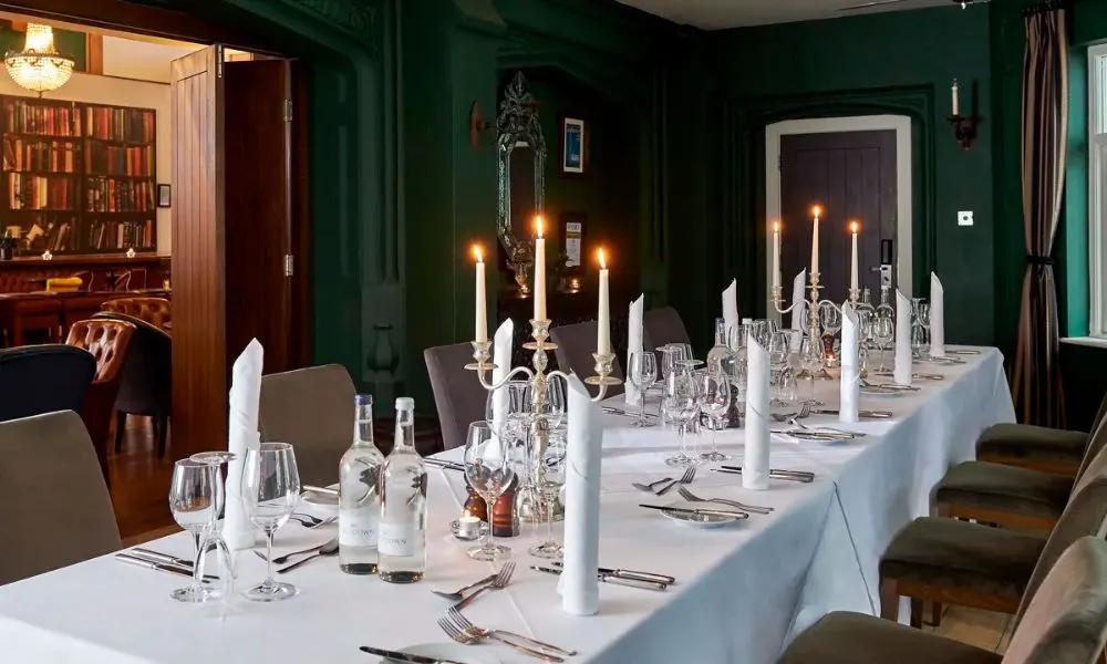 long banquet table with white tablecloth and candlesticks