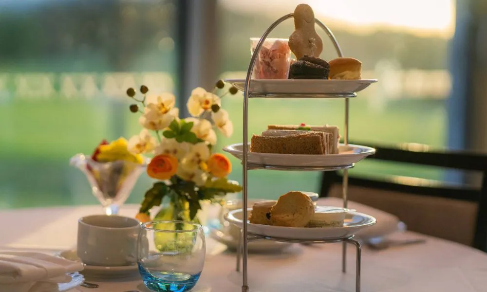 three tiered afternoon tea stand with cup of tea