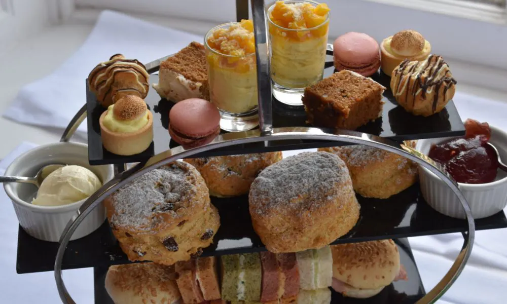 three tiered afternoon tea with sweet treats scones and sandwiches