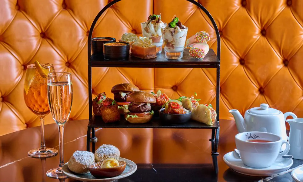 afternoon tea stand packed full of burgers, tacos and sweet treats