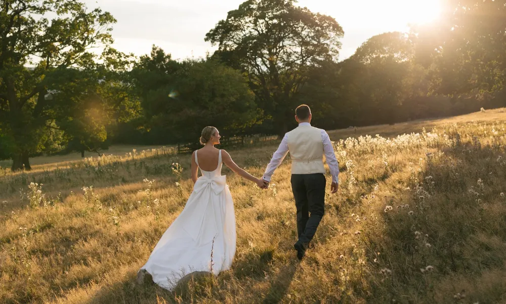 bride and groom in a field at Denton Reserve