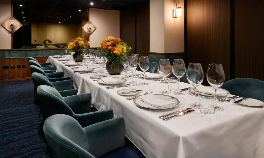 long banquet table with white tablecloth and floral arrangements