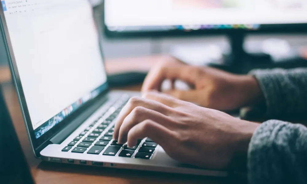 hands typing on a laptop