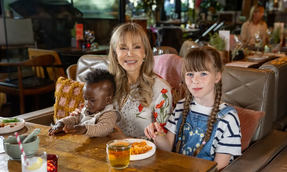 Karmel sat with two children of different ages 