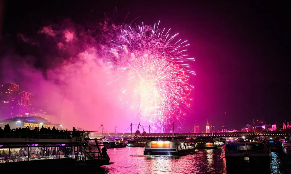 a boat on the river thames under fireworks