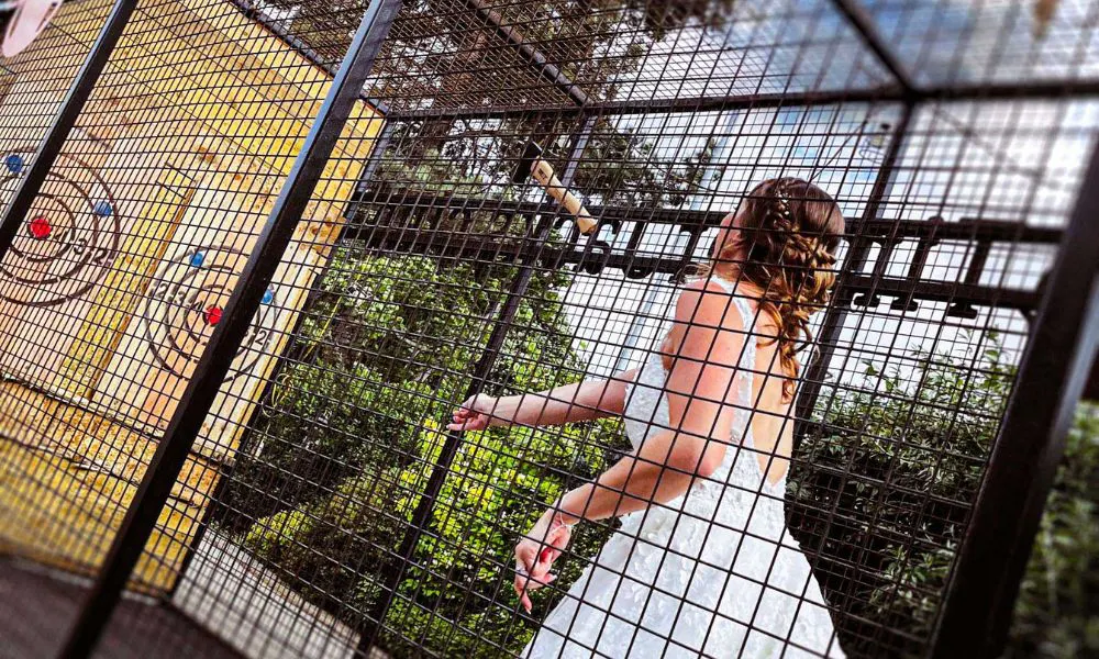 Bride throwing axe inside a metal cage