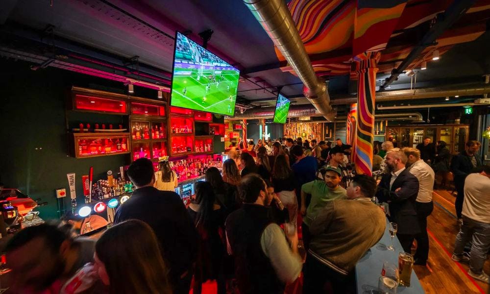 crowds watching football on a big screen in a pub