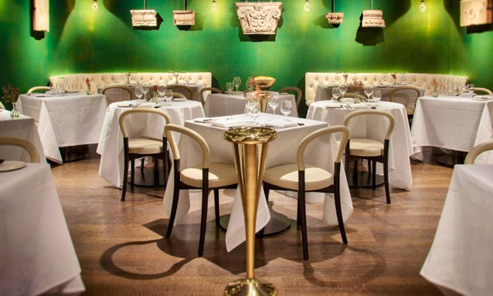 Green wall and white table cloth chairs