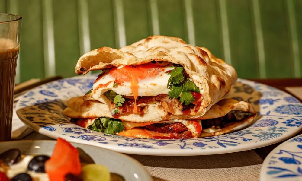 Naan bread with egg, bacon, and herbs inside