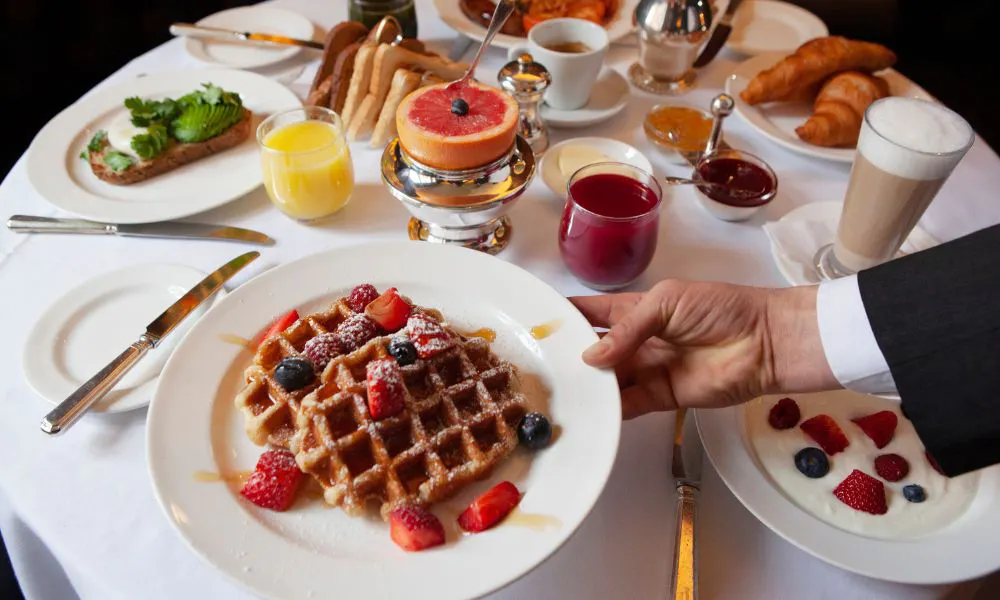 a breakfast spread with waffles and berries and pastries