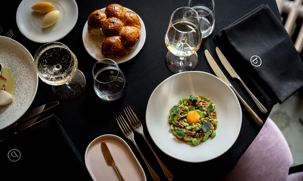 table with brioche bread and green beans in bowl