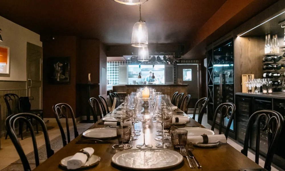 View of long private dinig chefs table looking into kithcen 