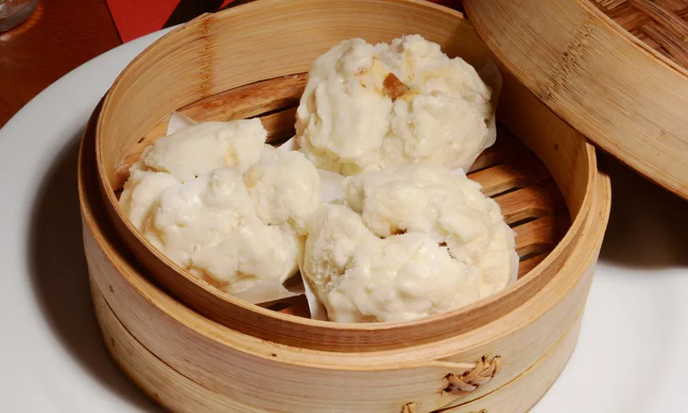 a wooden container of steamed dim sum