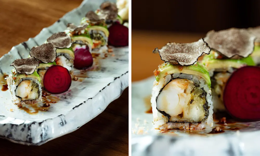 A close-up of a sushi roll topped with truffle
