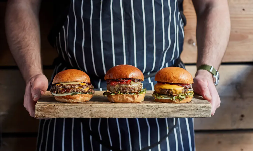 Three burgers on a board