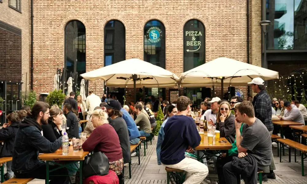 people sat in a beer garden outside a brewery