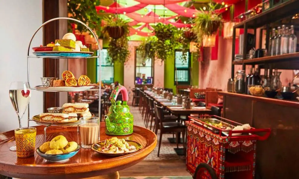 colourful restaurant with green teapot and tiers of cake