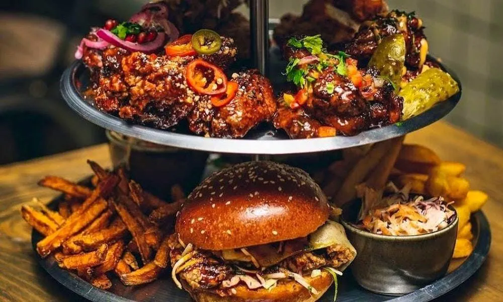Tiers of chicken wings, burgers, and cake