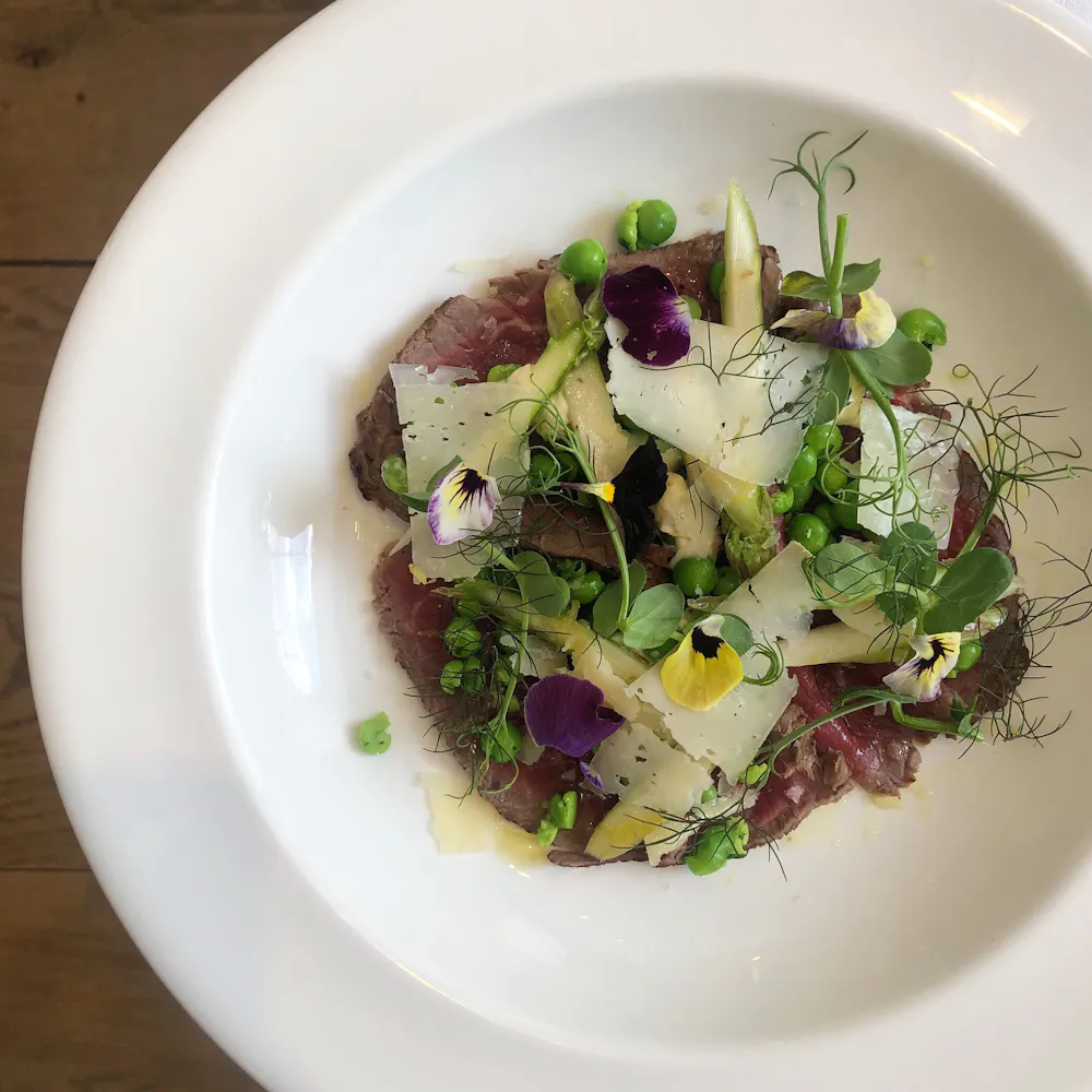 Beef carpaccio with peas, raw asparagus, pecorino and horseradish cream at Spring