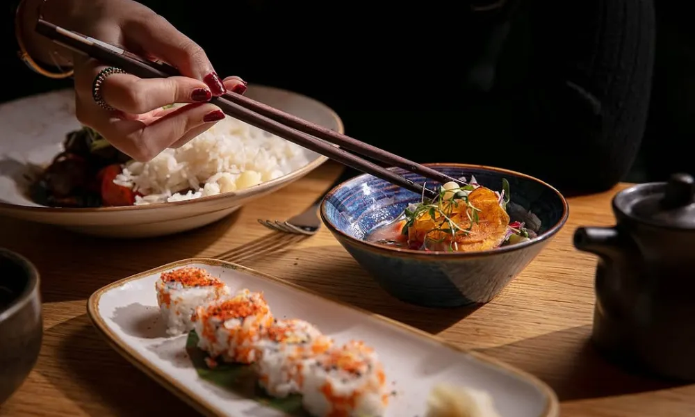 Chopsticks picking food from a small bowl