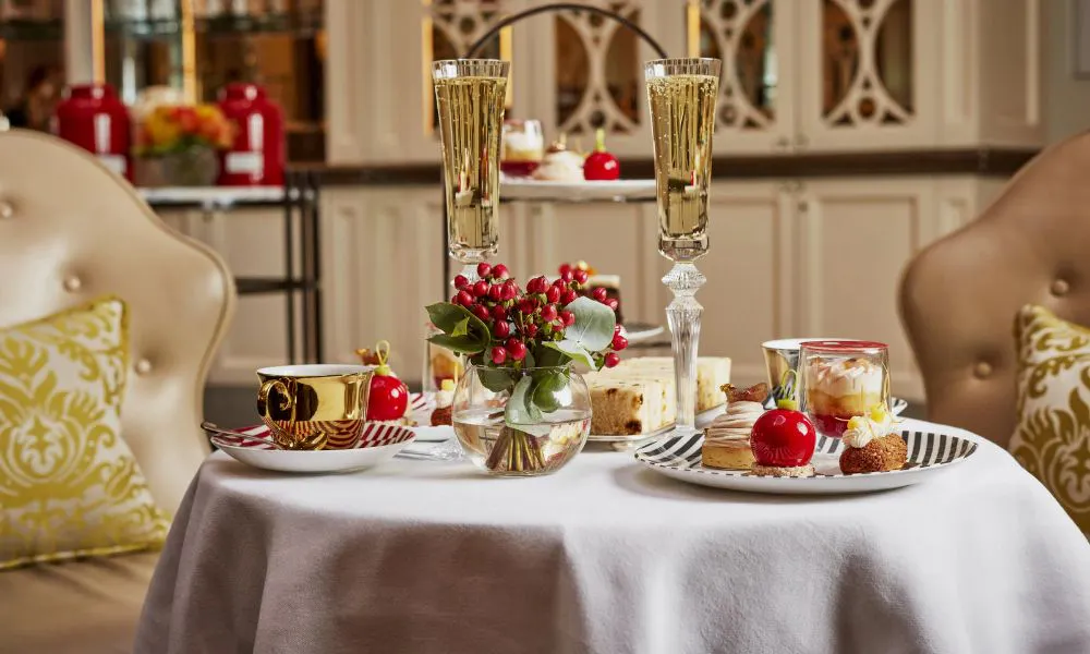 striped plates with christmas themed cakes, served with gold tea cups and glasses of Champagne