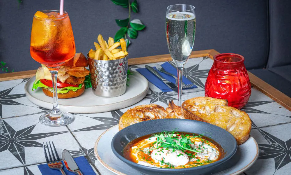 shakshuka, burger, Prosecco and an Aperol Spritz on a table