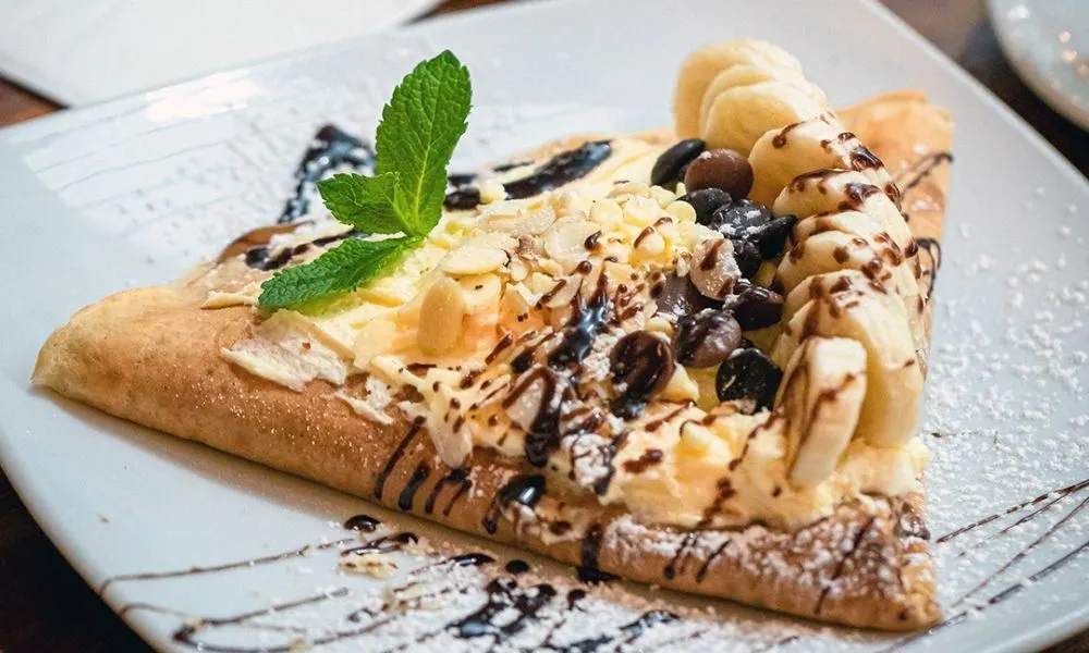 crepe topped with chocolate chips and banana