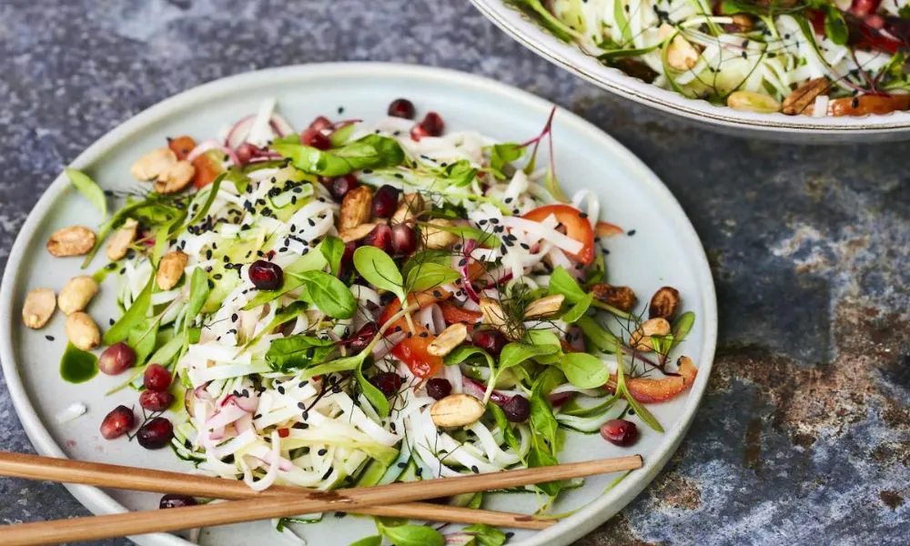 A salad with noodles on a dark marble table