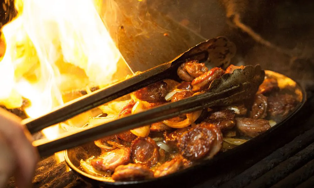 Meat cooked over flames