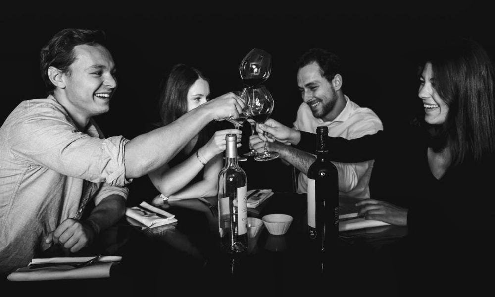 black and white image people cheersing a glass of wine