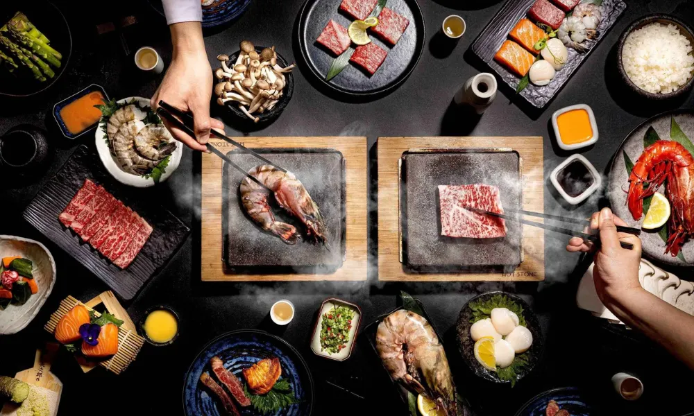 wagyu and prawn cooking on table top hot stones