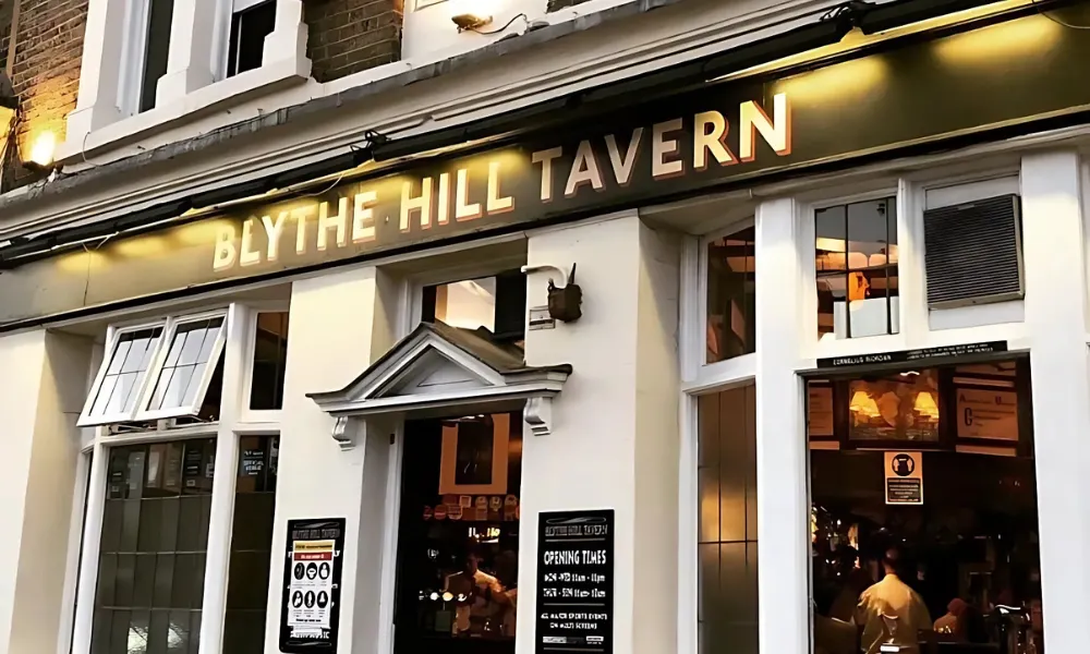 white and black pub exterior with gold sign writing